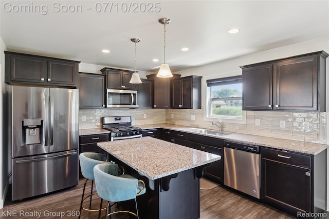 7057 Primrose Ln, Grand Blanc, MI 48439 - kitchen featuring appliances with stainless steel finishes, a kitchen island, a kitchen bar, dark brown cabinets, and dark wood-type flooring