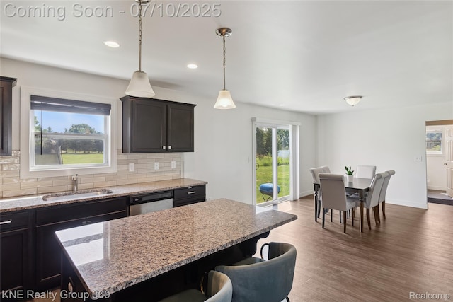 7057 Primrose Ln, Grand Blanc, MI 48439 - kitchen featuring stainless steel dishwasher, backsplash, a center island, dark wood-style floors, and light stone counters
