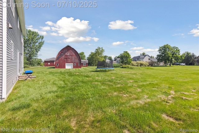 7057 Primrose Ln, Grand Blanc, MI 48439 - view of grassy yard with a barn, an outbuilding, a garage, and a trampoline