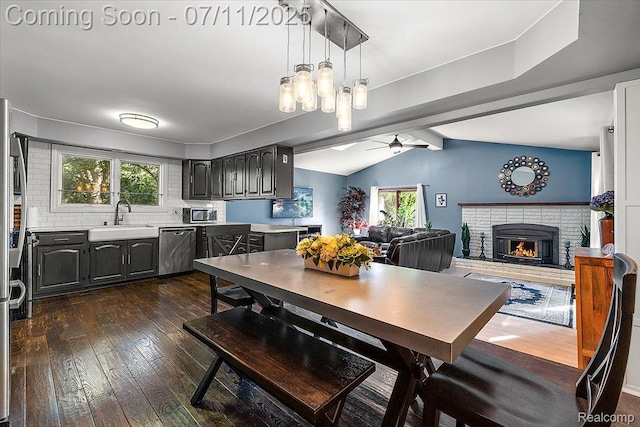 4674 Chapel Dr, Troy, MI 48085 - dining area featuring a brick fireplace, a ceiling fan, dark wood-type flooring, and healthy amount of natural light