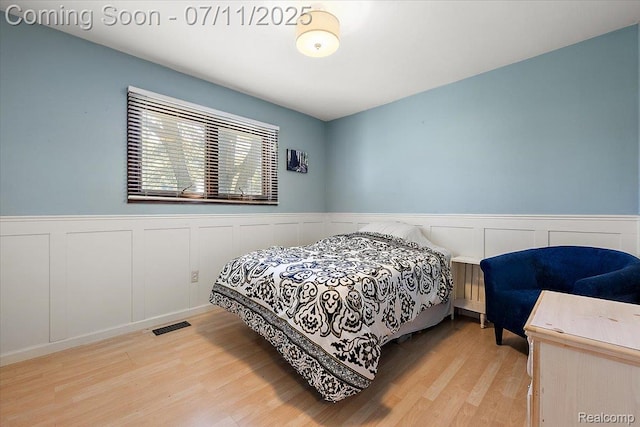 4674 Chapel Dr, Troy, MI 48085 - bedroom featuring wood finished floors, a wainscoted wall, and a decorative wall