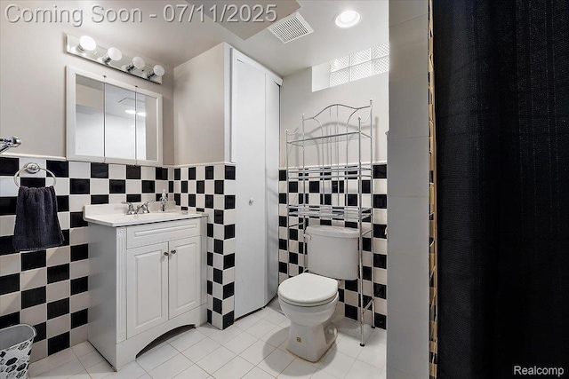 4674 Chapel Dr, Troy, MI 48085 - bathroom featuring tile walls, vanity, tile patterned floors, and wainscoting