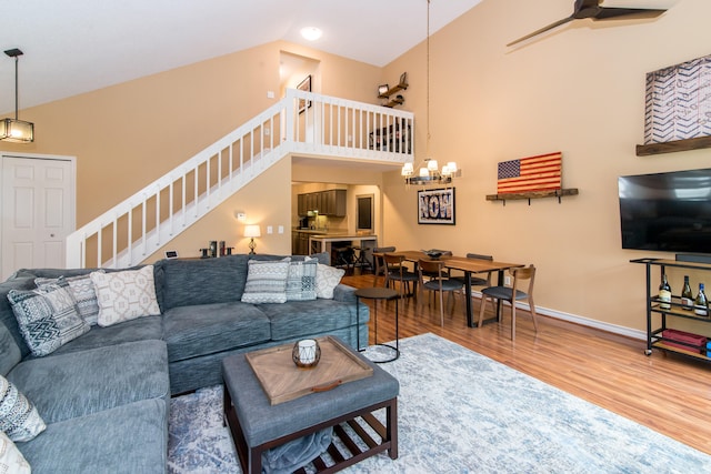 37516 N Laurel Park Dr, Livonia, MI 48152 - living room with stairs, wood finished floors, high vaulted ceiling, ceiling fan, and a chandelier