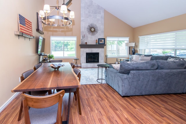 37516 N Laurel Park Dr, Livonia, MI 48152 - living room featuring a chandelier, high vaulted ceiling, plenty of natural light, wood finished floors, and a tiled fireplace