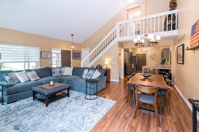 37516 N Laurel Park Dr, Livonia, MI 48152 - living room featuring dark wood-type flooring, stairway, a chandelier, and high vaulted ceiling