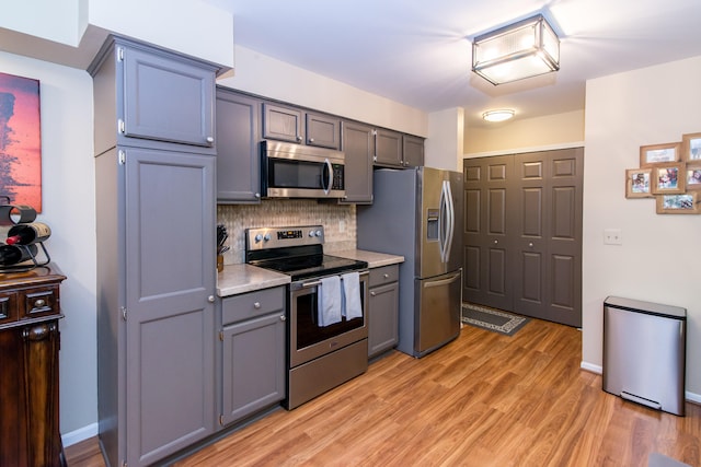 37516 N Laurel Park Dr, Livonia, MI 48152 - kitchen with stainless steel appliances, light countertops, decorative backsplash, light wood-style flooring, and gray cabinetry