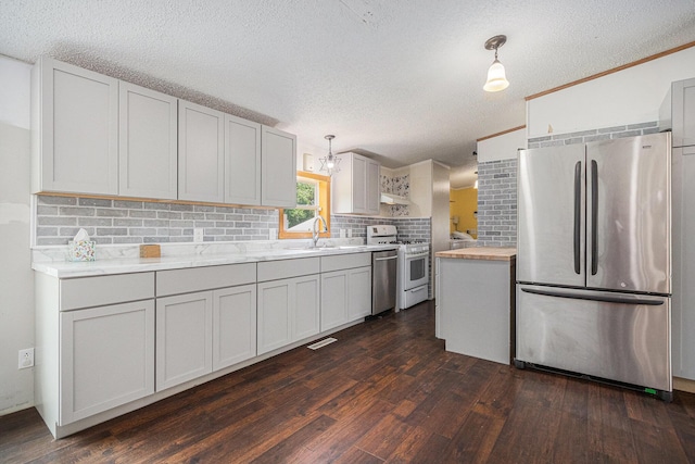 36466 M 40, Paw Paw, MI 49079 - kitchen with stainless steel appliances, dark wood-style floors, backsplash, a textured ceiling, and under cabinet range hood