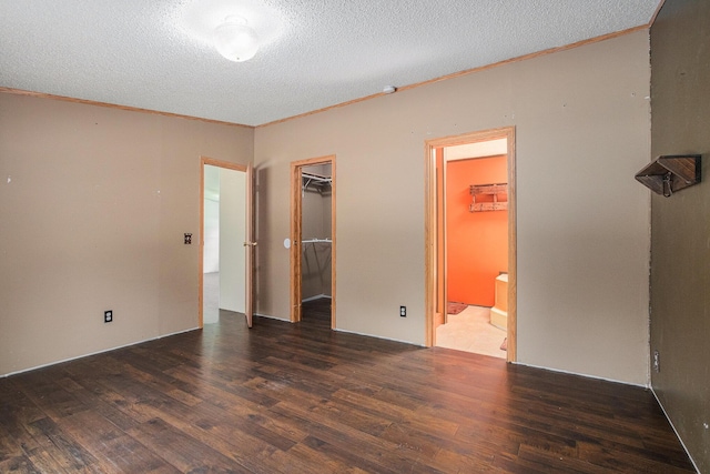 36466 M 40, Paw Paw, MI 49079 - unfurnished bedroom featuring wood finished floors, ornamental molding, a walk in closet, a textured ceiling, and ensuite bathroom
