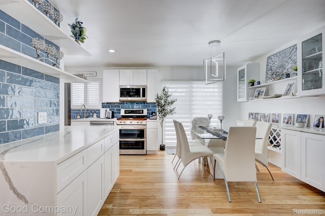 29755 Rosemond Dr, Southfield, MI 48025 - kitchen with open shelves, stainless steel appliances, backsplash, white cabinetry, and light wood finished floors