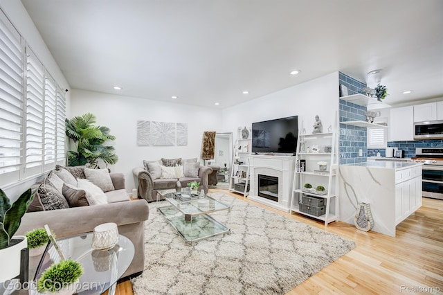 29755 Rosemond Dr, Southfield, MI 48025 - living room featuring a glass covered fireplace, light wood-type flooring, and recessed lighting