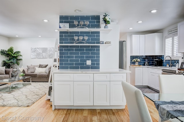 29755 Rosemond Dr, Southfield, MI 48025 - kitchen with light countertops, tasteful backsplash, white cabinets, open floor plan, and light wood-style floors