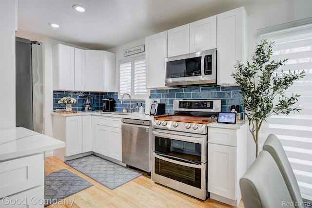 29755 Rosemond Dr, Southfield, MI 48025 - kitchen with appliances with stainless steel finishes, tasteful backsplash, white cabinets, light wood-style floors, and recessed lighting