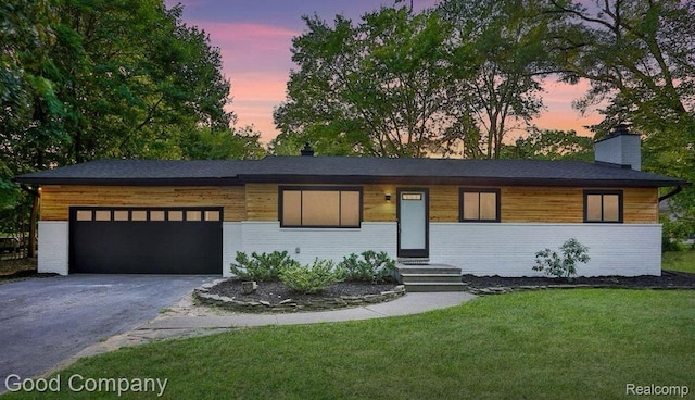 29755 Rosemond Dr, Southfield, MI 48025 - view of front of home with asphalt driveway, an attached garage, a yard, and a chimney