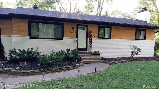 29755 Rosemond Dr, Southfield, MI 48025 - view of front of house featuring a chimney, a front yard, a shingled roof, and brick siding