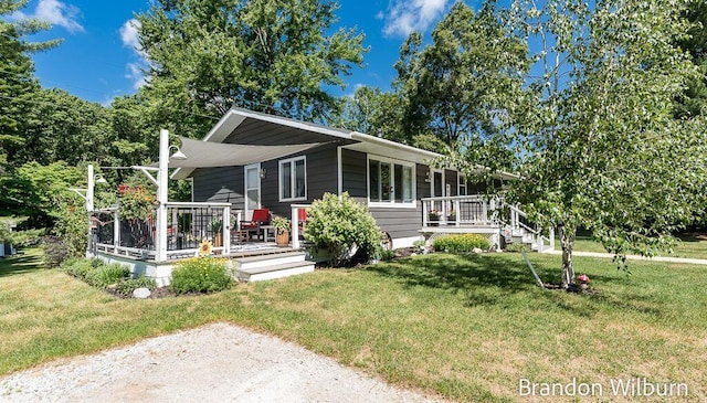 2289 S Sullivan Rd, Ravenna, MI 49451 - view of front of house featuring a front lawn and a wooden deck