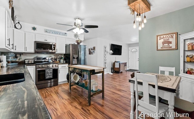 2289 S Sullivan Rd, Ravenna, MI 49451 - kitchen with appliances with stainless steel finishes, a ceiling fan, dark countertops, white cabinets, and light wood-style flooring