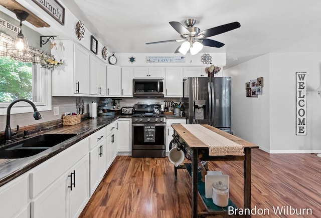 2289 S Sullivan Rd, Ravenna, MI 49451 - kitchen with appliances with stainless steel finishes, dark countertops, tasteful backsplash, a ceiling fan, and wood finished floors