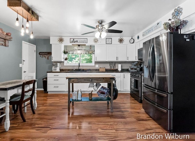 2289 S Sullivan Rd, Ravenna, MI 49451 - kitchen with stainless steel fridge, range with gas cooktop, dark countertops, and black microwave