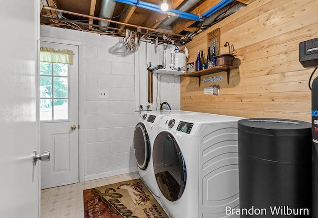 2289 S Sullivan Rd, Ravenna, MI 49451 - washroom with independent washer and dryer, light flooring, and wooden walls