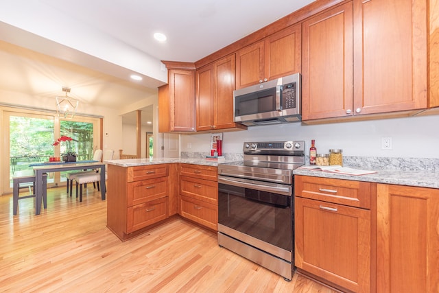2728 Kimberley Rd, Ann Arbor, MI 48104 - kitchen with appliances with stainless steel finishes, a peninsula, brown cabinetry, and recessed lighting