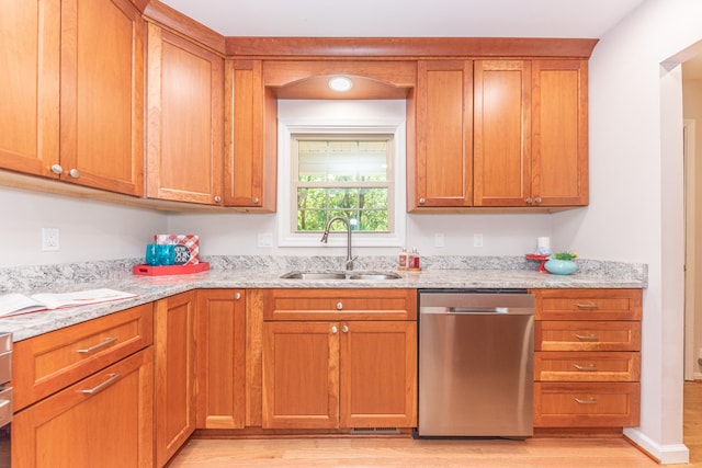 2728 Kimberley Rd, Ann Arbor, MI 48104 - kitchen featuring stainless steel dishwasher, light wood-style floors, light stone counters, and brown cabinetry