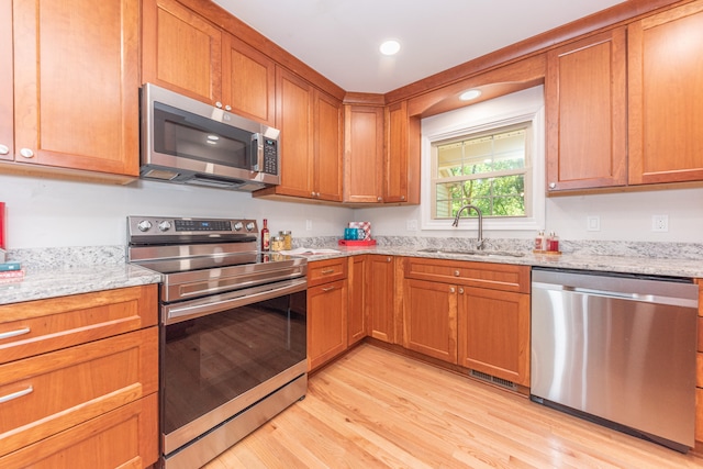 2728 Kimberley Rd, Ann Arbor, MI 48104 - kitchen featuring appliances with stainless steel finishes, light wood-style flooring, brown cabinetry, and recessed lighting
