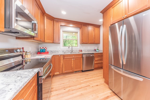 2728 Kimberley Rd, Ann Arbor, MI 48104 - kitchen with appliances with stainless steel finishes, light wood-style flooring, brown cabinets, light stone countertops, and recessed lighting