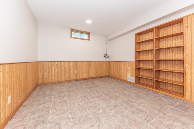 2728 Kimberley Rd, Ann Arbor, MI 48104 - spare room with wainscoting, wooden walls, and stone finish floors
