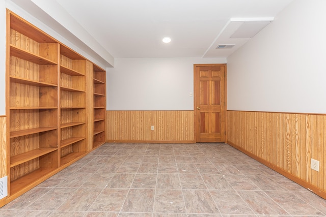 2728 Kimberley Rd, Ann Arbor, MI 48104 - empty room featuring a wainscoted wall, wooden walls, and stone finish flooring