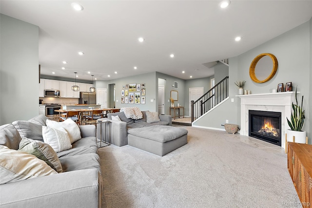 3860 Summit Dr, Sterling Heights, MI 48314 - living area featuring light colored carpet, recessed lighting, a premium fireplace, and stairway