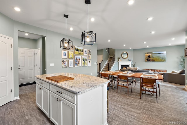 3860 Summit Dr, Sterling Heights, MI 48314 - kitchen with open floor plan, recessed lighting, a kitchen island, white cabinets, and light stone countertops