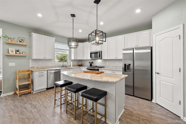 3860 Summit Dr, Sterling Heights, MI 48314 - kitchen featuring appliances with stainless steel finishes, a center island, white cabinets, tasteful backsplash, and open shelves