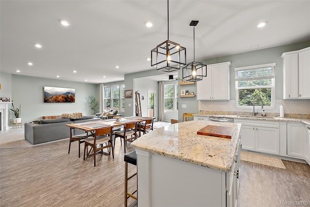 3860 Summit Dr, Sterling Heights, MI 48314 - kitchen with a center island, recessed lighting, white cabinetry, open floor plan, and light wood-style floors