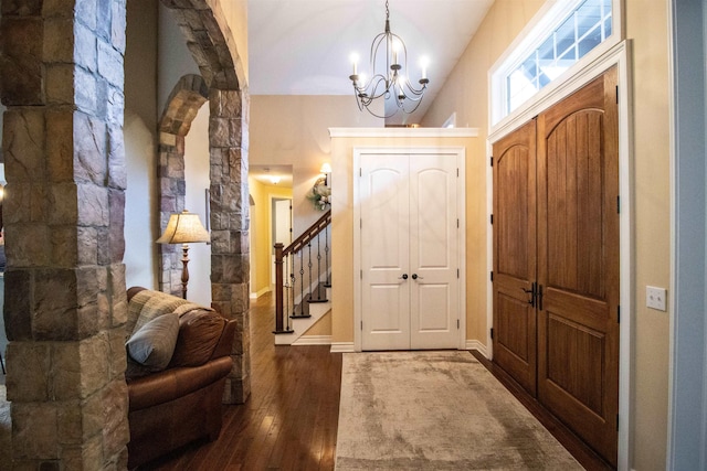 7380 Vassar Rd, Grand Blanc, MI 48439 - foyer featuring a chandelier, dark wood finished floors, arched walkways, vaulted ceiling, and stairway