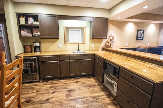 7380 Vassar Rd, Grand Blanc, MI 48439 - kitchen featuring beverage cooler, a peninsula, wood finished floors, dark brown cabinets, and wooden counters