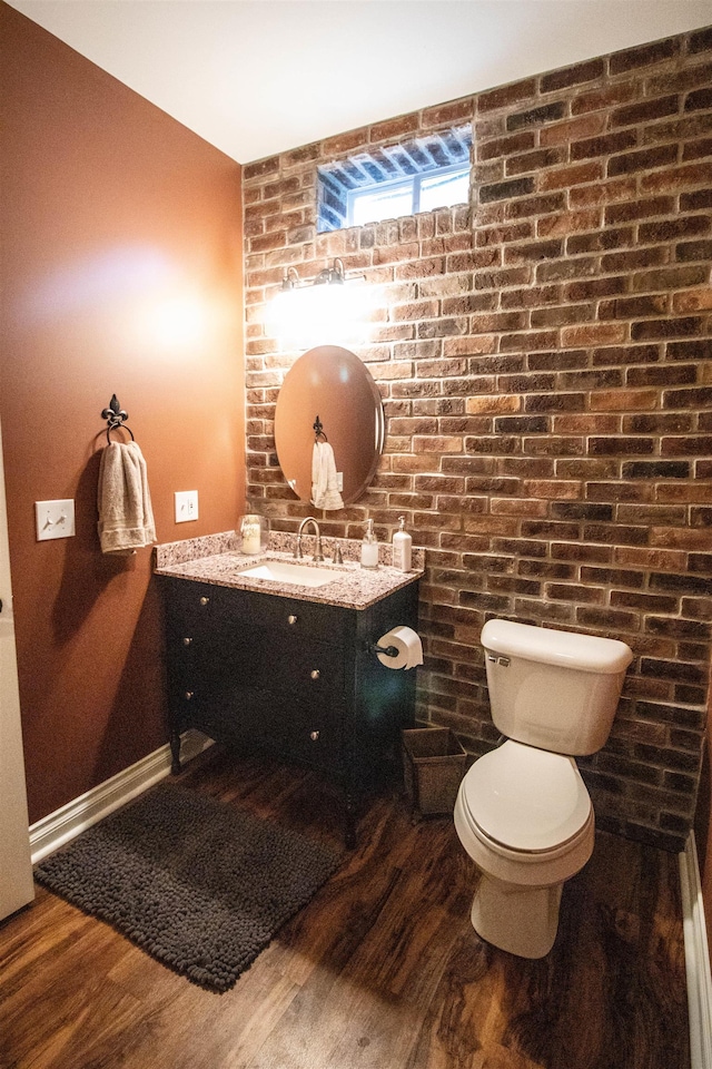 7380 Vassar Rd, Grand Blanc, MI 48439 - bathroom with vanity, wood finished floors, and brick wall