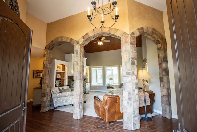 7380 Vassar Rd, Grand Blanc, MI 48439 - living area with arched walkways, ornate columns, wood finished floors, a high ceiling, and a chandelier