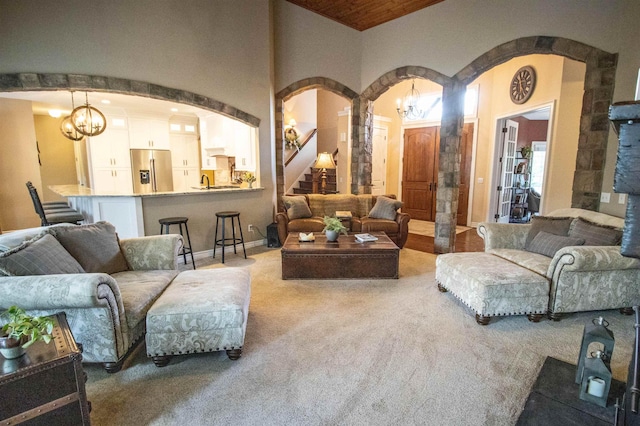 7380 Vassar Rd, Grand Blanc, MI 48439 - living area with arched walkways, carpet flooring, a chandelier, and stairs