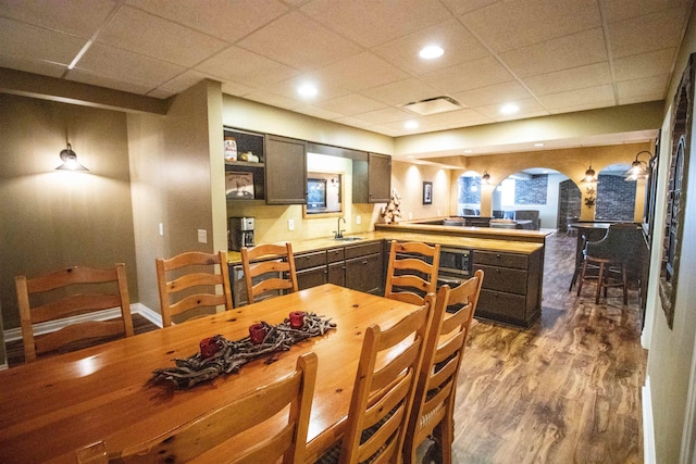 7380 Vassar Rd, Grand Blanc, MI 48439 - dining area with arched walkways, wood finished floors, and a paneled ceiling