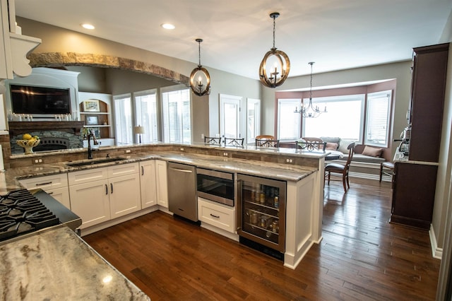 7380 Vassar Rd, Grand Blanc, MI 48439 - kitchen featuring a chandelier, appliances with stainless steel finishes, beverage cooler, light stone countertops, and white cabinetry