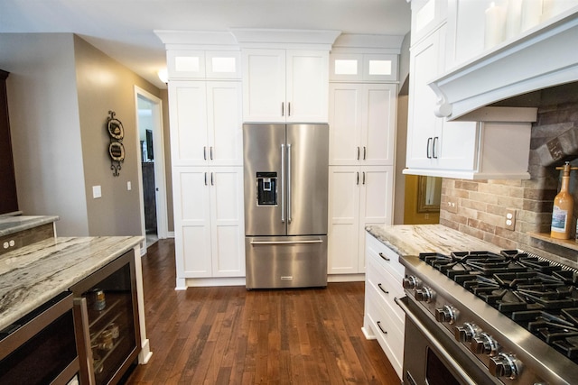 7380 Vassar Rd, Grand Blanc, MI 48439 - kitchen with premium appliances, custom exhaust hood, white cabinets, glass insert cabinets, and backsplash