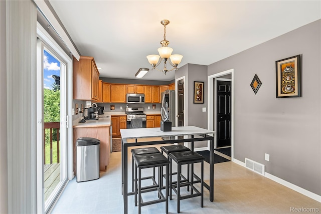 838 Star Dr, Davison, MI 48423 - kitchen with stainless steel appliances, a chandelier, light countertops, and decorative light fixtures
