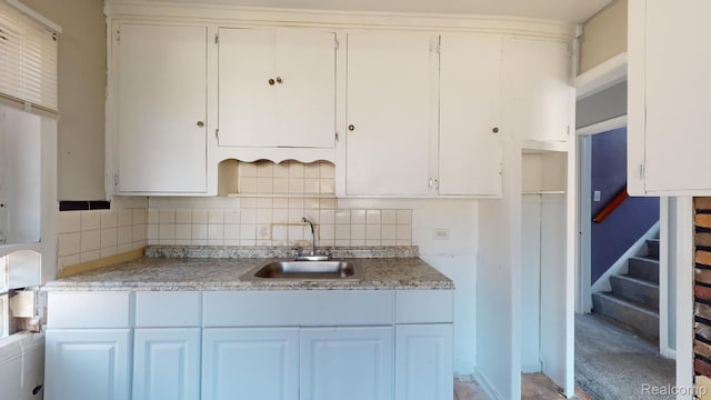 12660 Duchess St, Detroit, MI 48224 - kitchen with tasteful backsplash, light countertops, and white cabinetry