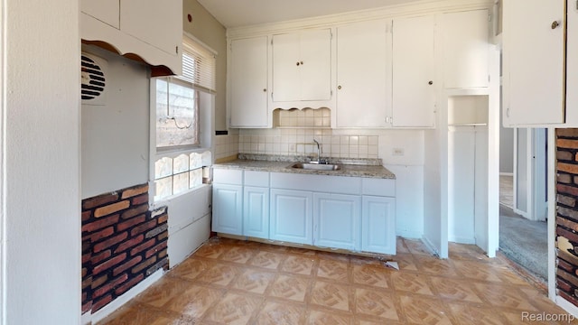 12660 Duchess St, Detroit, MI 48224 - kitchen featuring light countertops, tasteful backsplash, and white cabinets