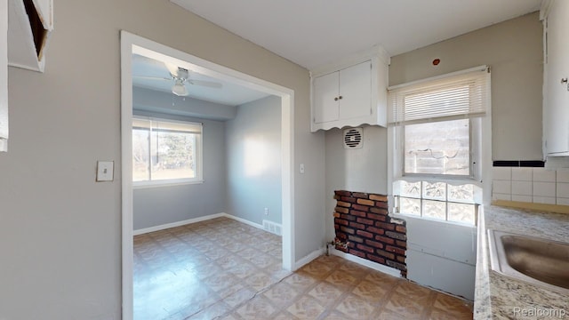 12660 Duchess St, Detroit, MI 48224 - kitchen with light floors, ceiling fan, light countertops, and white cabinets