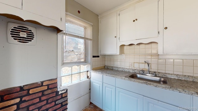 12660 Duchess St, Detroit, MI 48224 - kitchen with healthy amount of natural light, white cabinets, tasteful backsplash, and light countertops