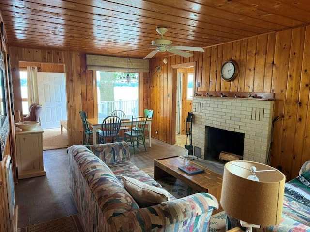 14450 Park Dr, Mecosta, MI 49332 - carpeted living area with wood ceiling, wood walls, ceiling fan, and a brick fireplace