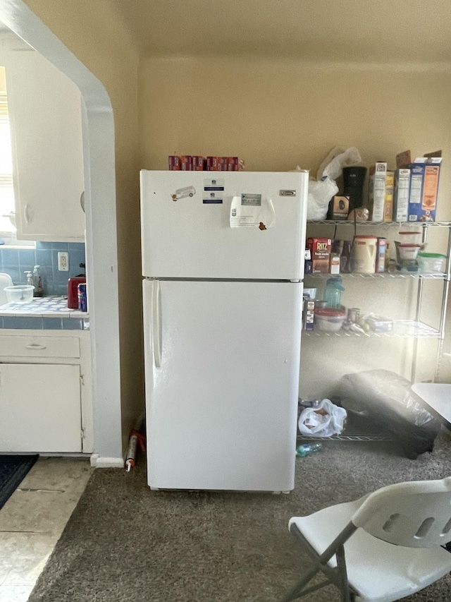 19624 Anglin St, Detroit, MI 48234 - kitchen with freestanding refrigerator, tile countertops, white cabinetry, and tasteful backsplash