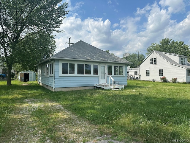 3363 Parkwood Ave, Monroe, MI 48162 - back of property with a storage shed, entry steps, a lawn, and a shingled roof