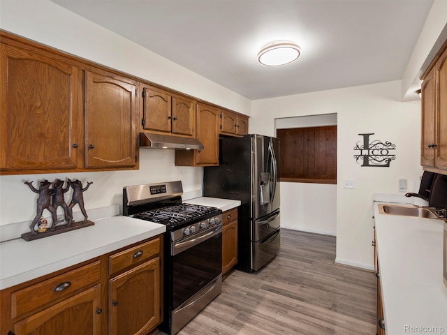 32721 Stoneybrook Ln, Macomb, MI 48026 - kitchen featuring stainless steel appliances, under cabinet range hood, light countertops, light wood-type flooring, and brown cabinets